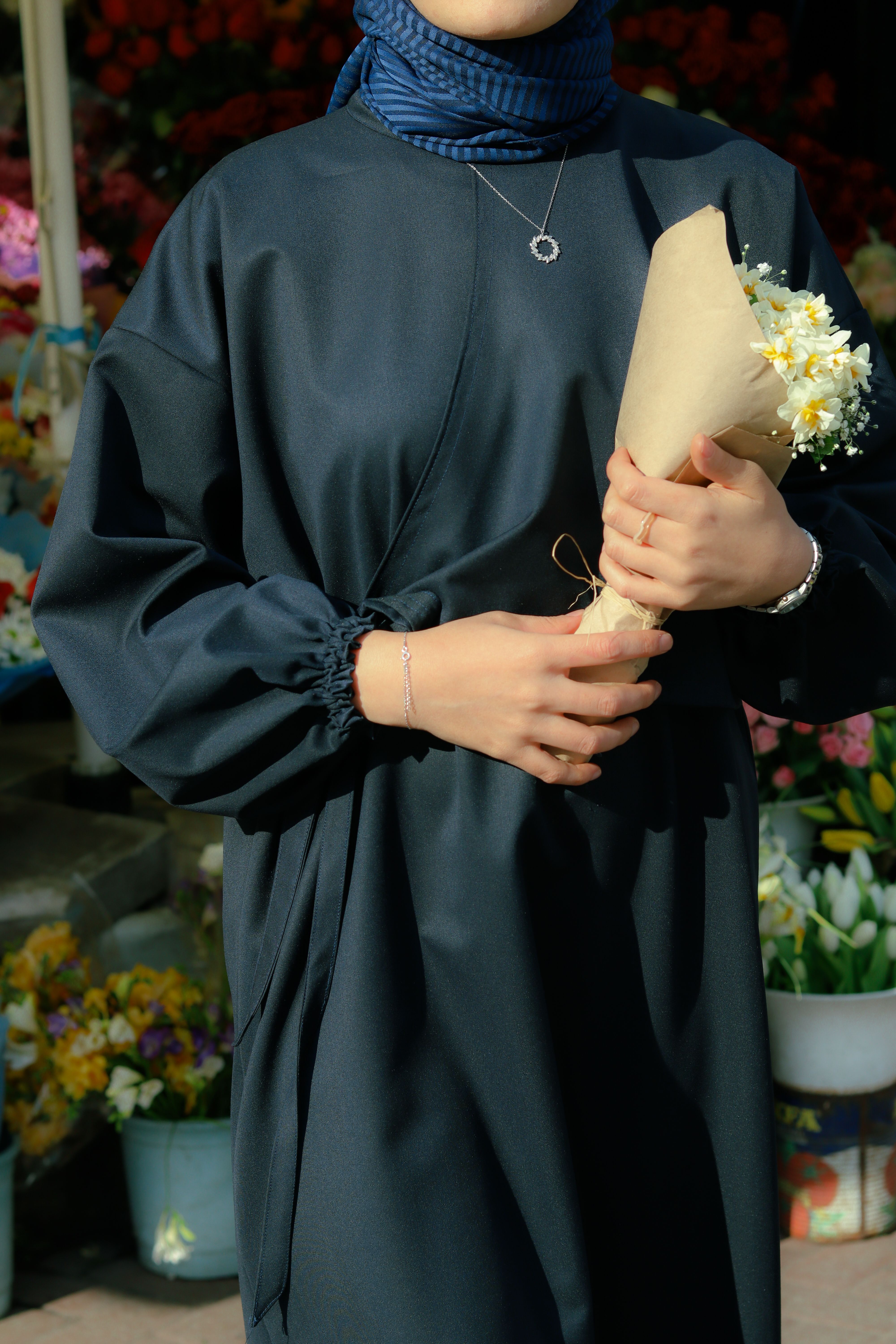 A woman in a black dress holding flowers · Free Stock Photo