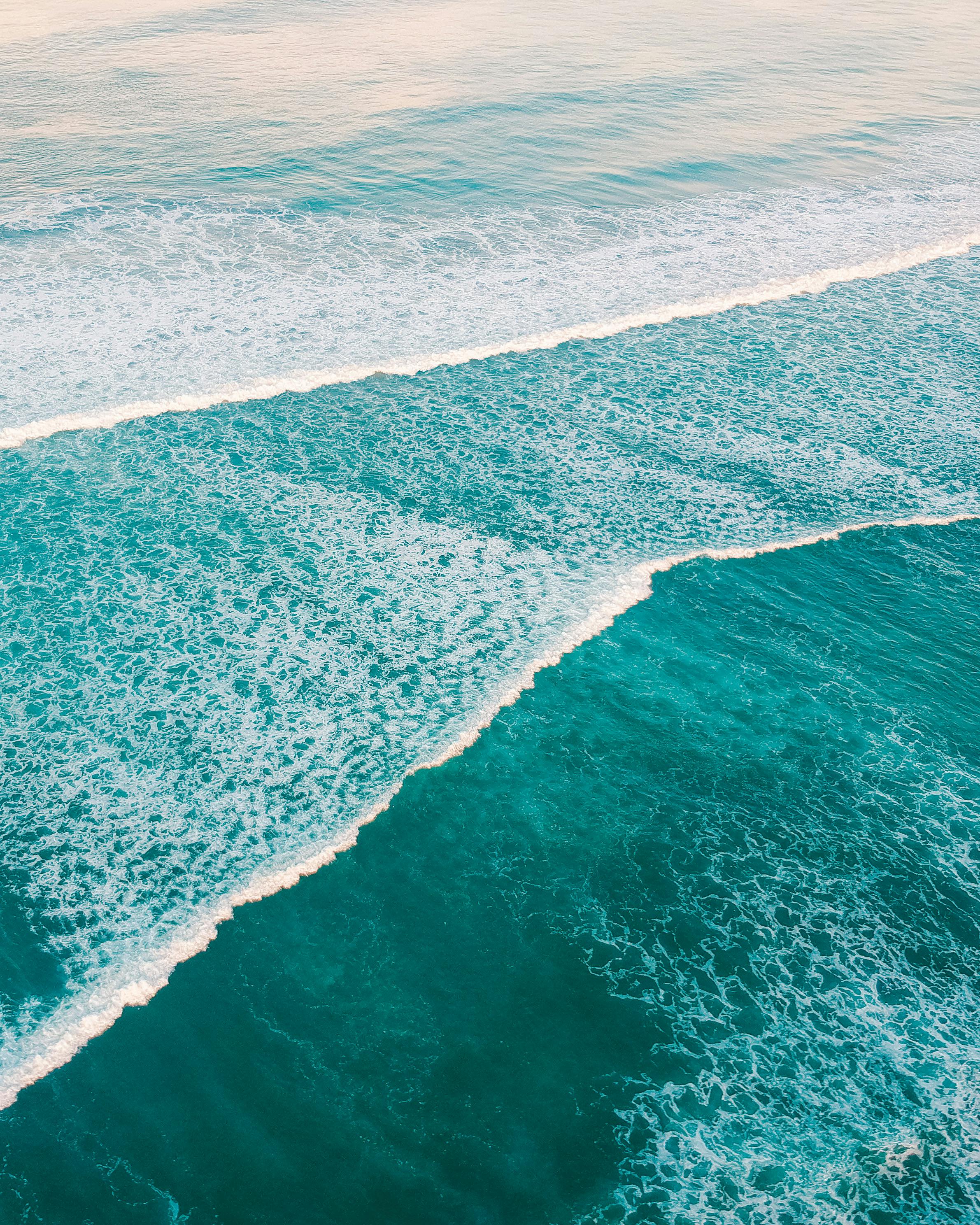 Aerial shot of vibrant ocean waves in Pangandaran, Indonesia, showcasing natural beauty.