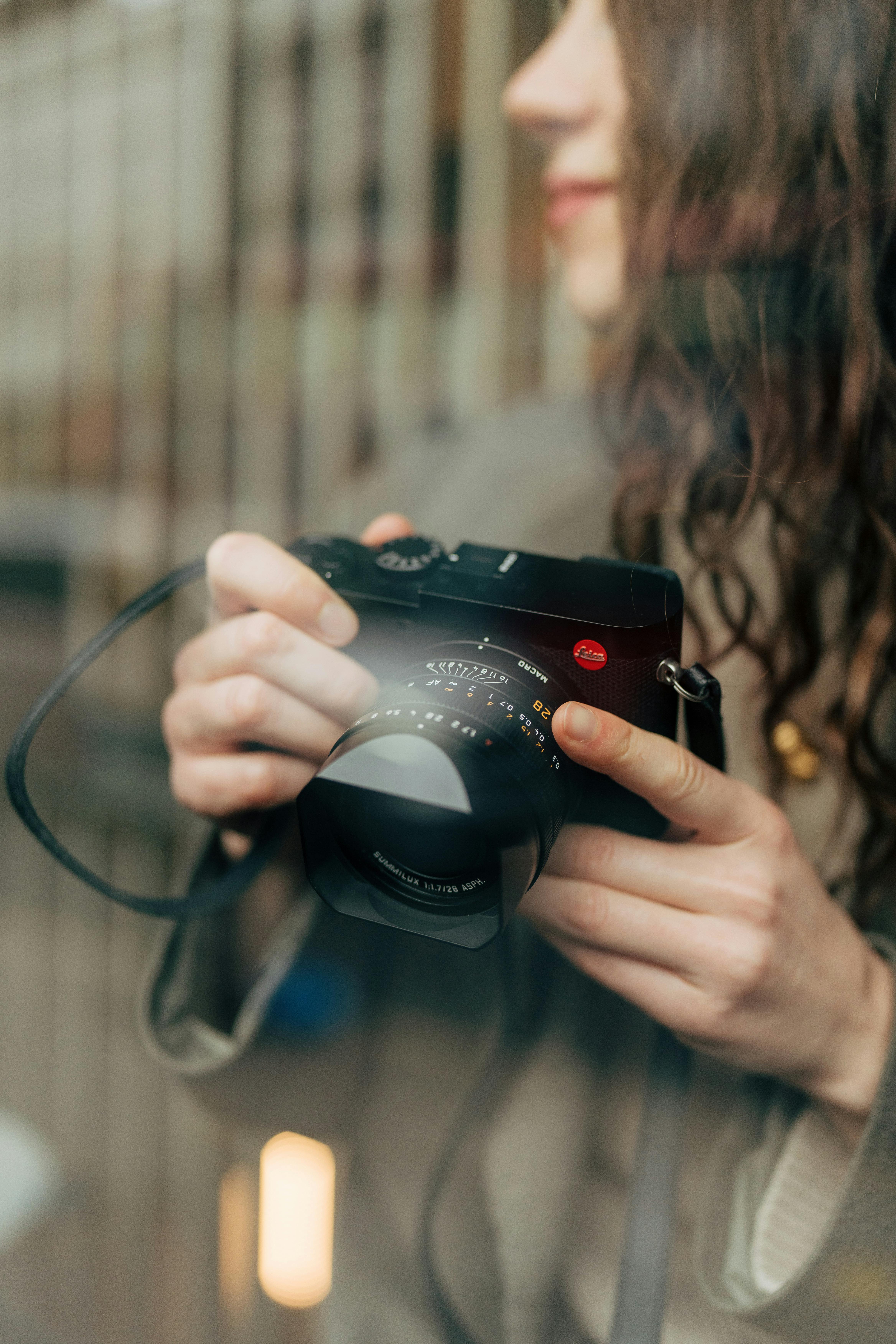 A woman holding a camera, capturing a candid outdoor moment in the UK.