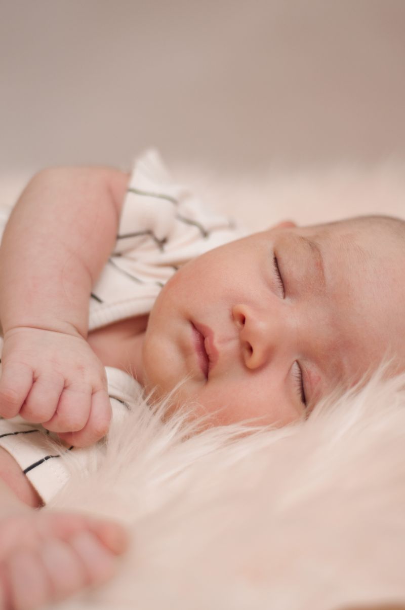 A peaceful baby sleeping soundly on a soft, plush blanket with eyes closed
