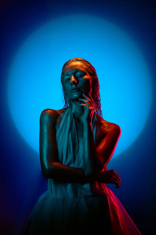 A woman in a white dress with blue light