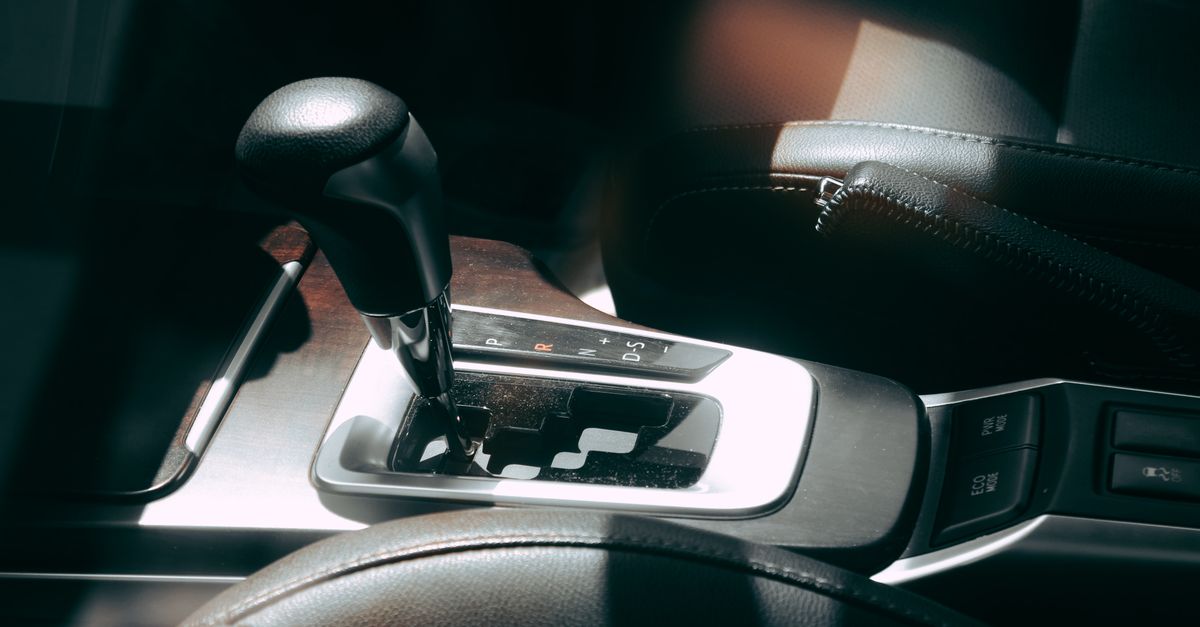 Close-up of a car's gear shift lever and interior, showcasing elegance and design.