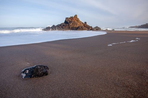 Free Serene beach scene with rock formation and gentle waves on the Oregon coast. Stock Photo