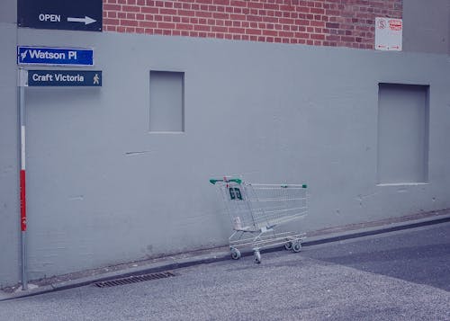 A shopping cart is parked in front of a building