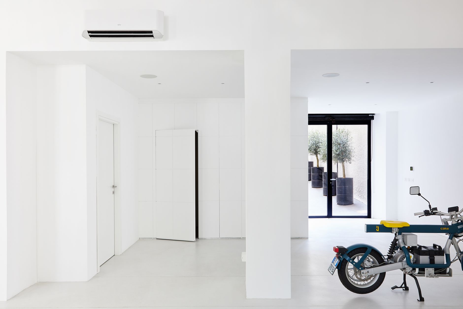 elegant garage transformation for beginners Bright minimalist room featuring a modern motorbike and stylish decor elements.