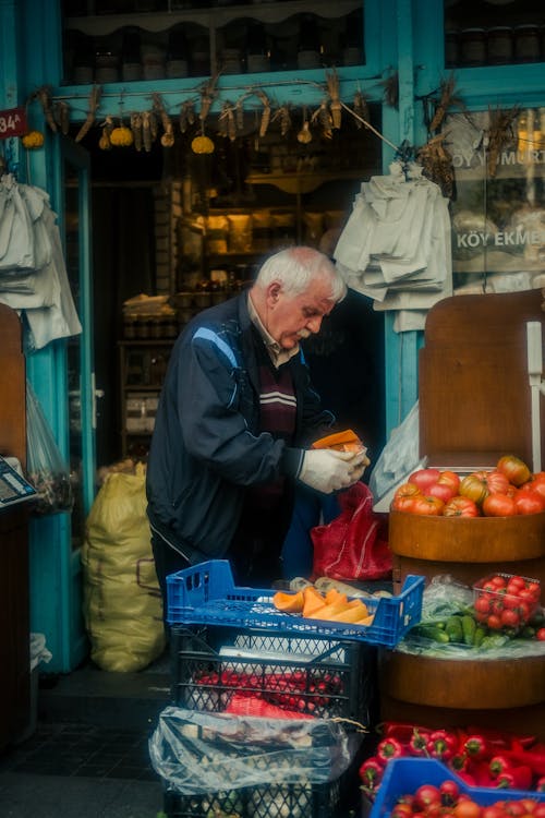 An older man is shopping for fruit at a market