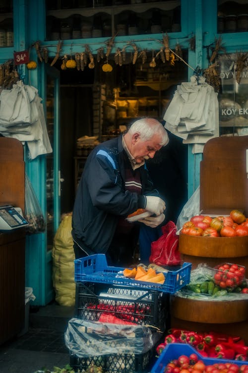 An older man is shopping for vegetables at a market