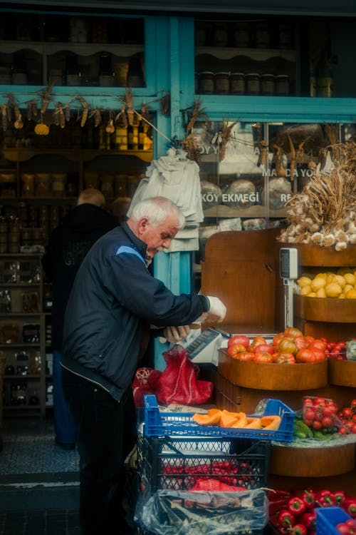 An old man is shopping for fruits and vegetables