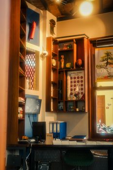 A cozy office setting with decor, books, and a small monitor on a desk.