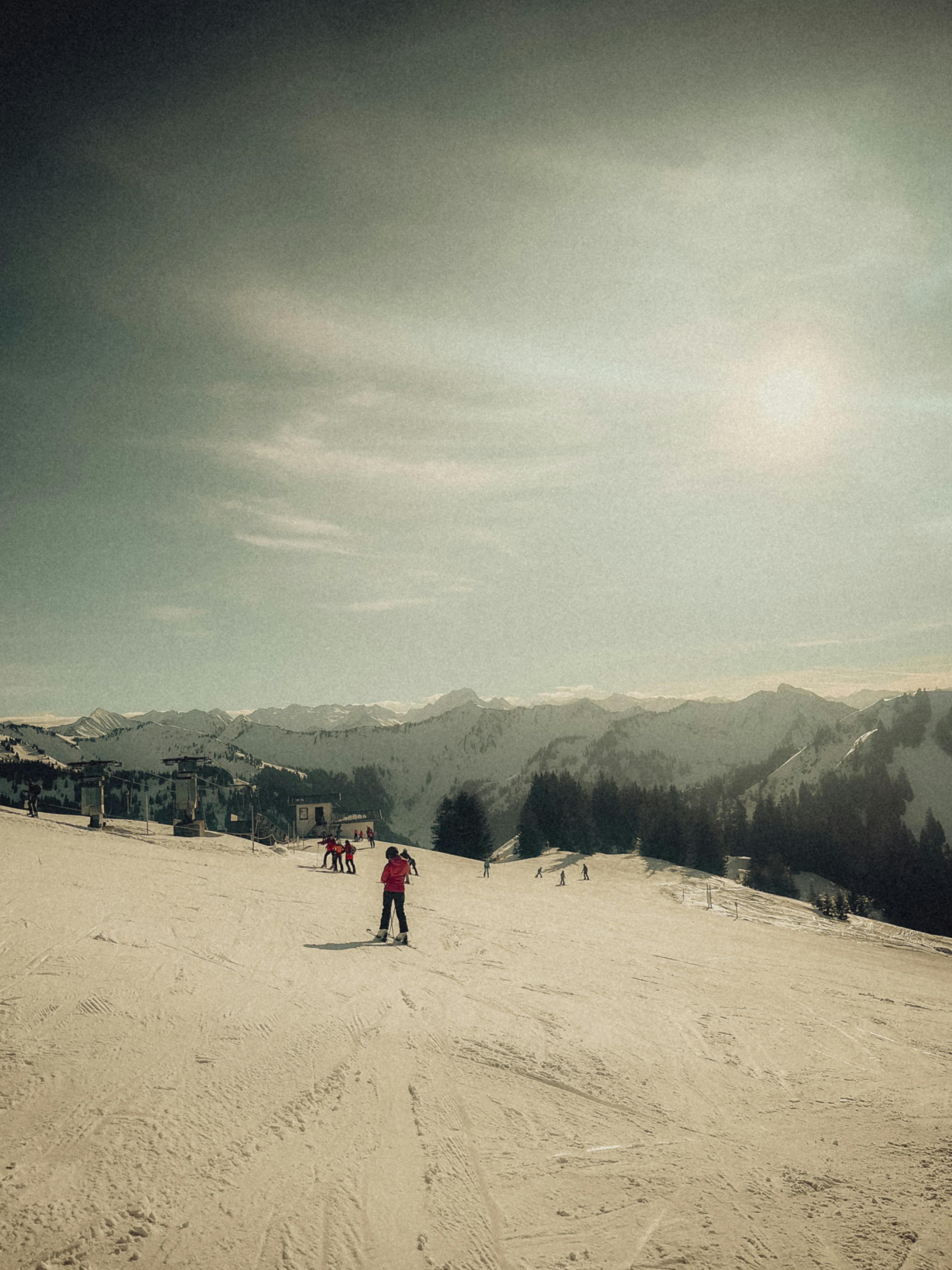 Prescription Goggle Inserts - Skiers glide down the sunlit snowy mountain slopes on a clear winter day.