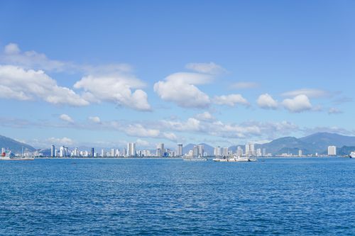 Free View of Nha Trang city skyline with clear blue ocean and sky, showcasing urban and natural beauty. Stock Photo