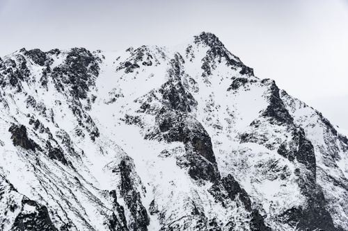 Free A breathtaking view of a snow-covered mountain peak under a clear winter sky. Stock Photo