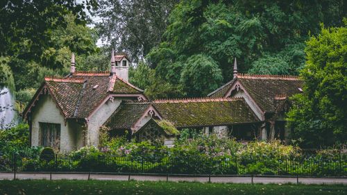 Free Enchanting Gothic-style bungalow nestled in a lush London garden surrounded by vibrant greenery. Stock Photo