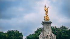 在伦敦多云的天空下，雄伟的维多利亚纪念雕像展现出历史的优雅