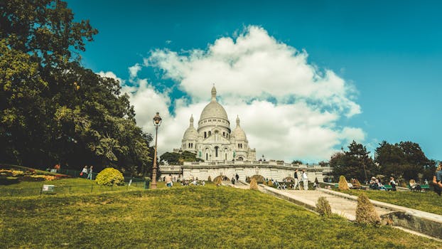 在阳光明媚的日子里，人们享受着公园的乐趣，圣心大教堂的景色十分壮丽