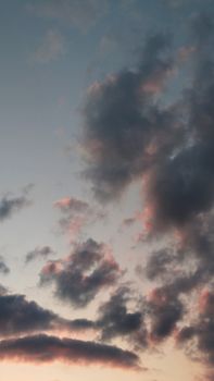 Capture of a tranquil evening sky with soft pastel clouds at sunset, creating a calming atmosphere.