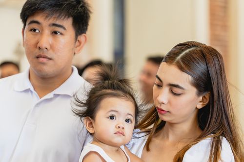 Free A young family with parents and their baby in an indoor setting. Stock Photo
