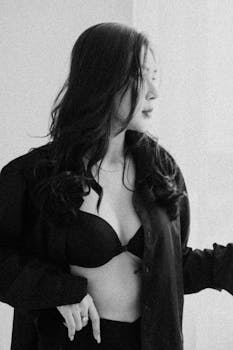 Elegant black and white portrait featuring a woman in a stylish fashion pose.