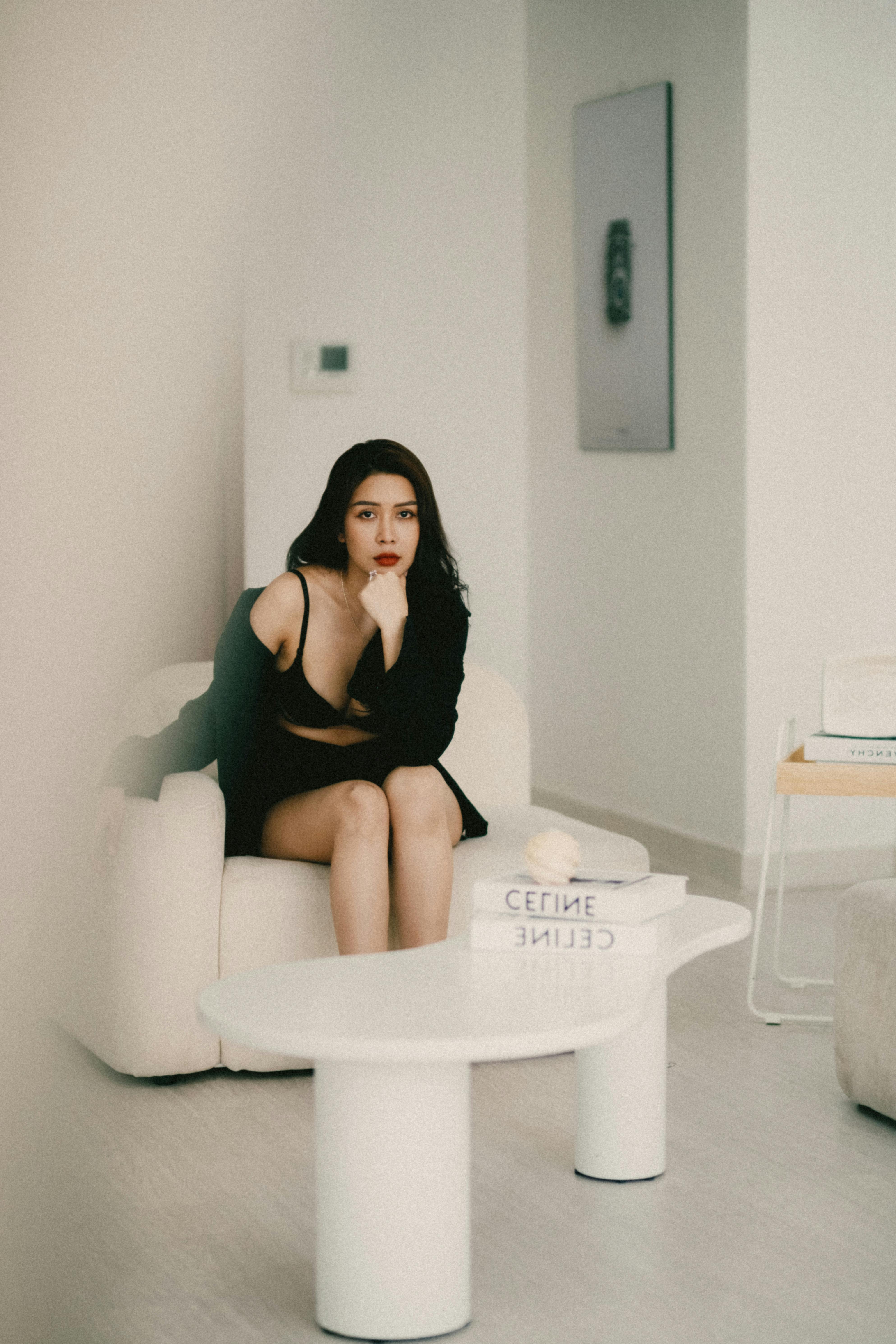 Fashionable woman seated in a modern living room. Elegant ambiance with clean design.