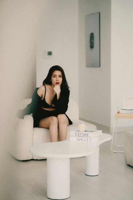 Fashionable woman seated in a modern living room. Elegant ambiance with clean design.
