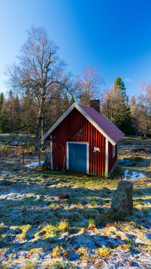 A Red Hut Standing on a Frosty Field 