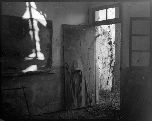 An old photo of a room with a window and a door