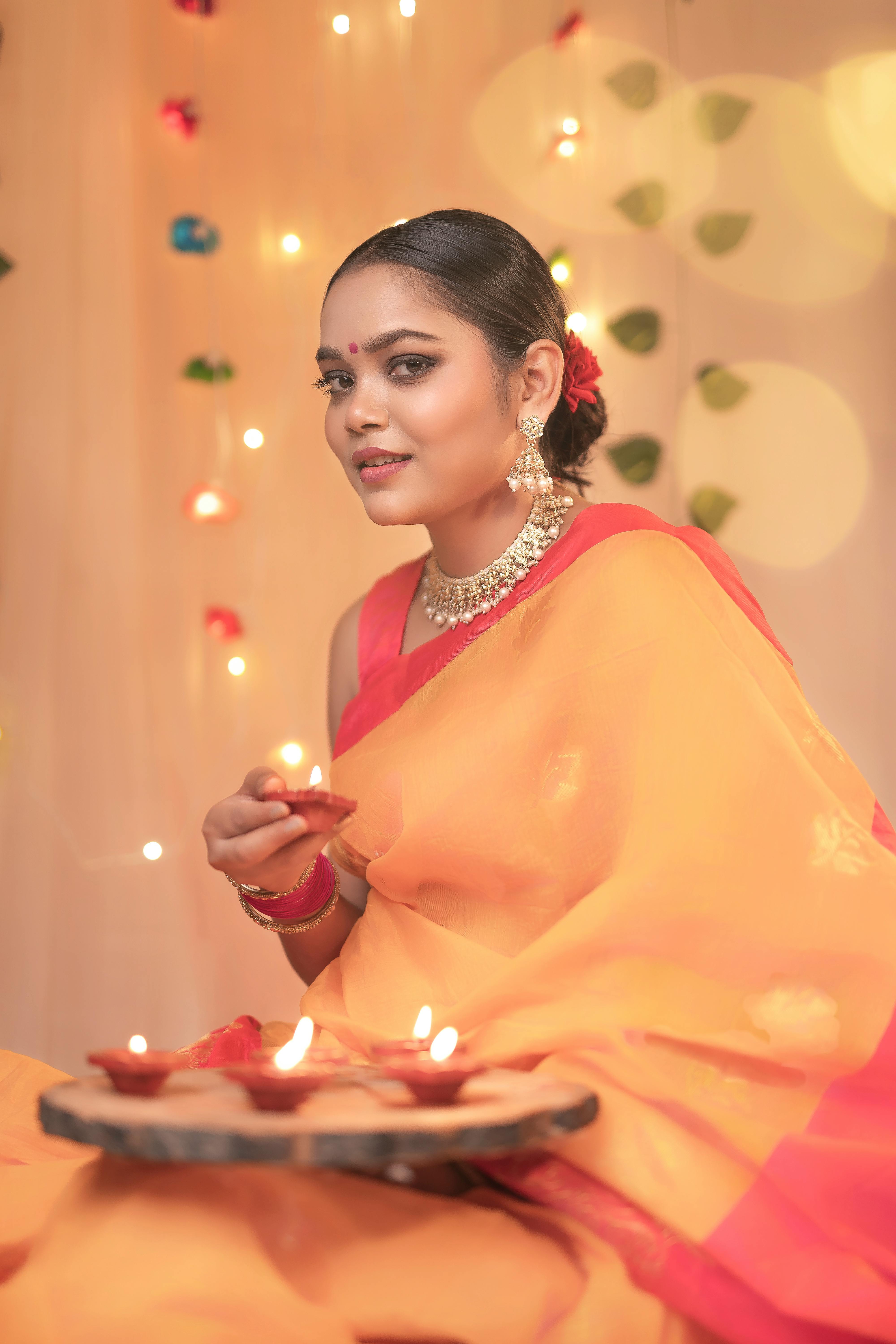 Elegant Indian woman holding traditional diyas for wedding ceremony
