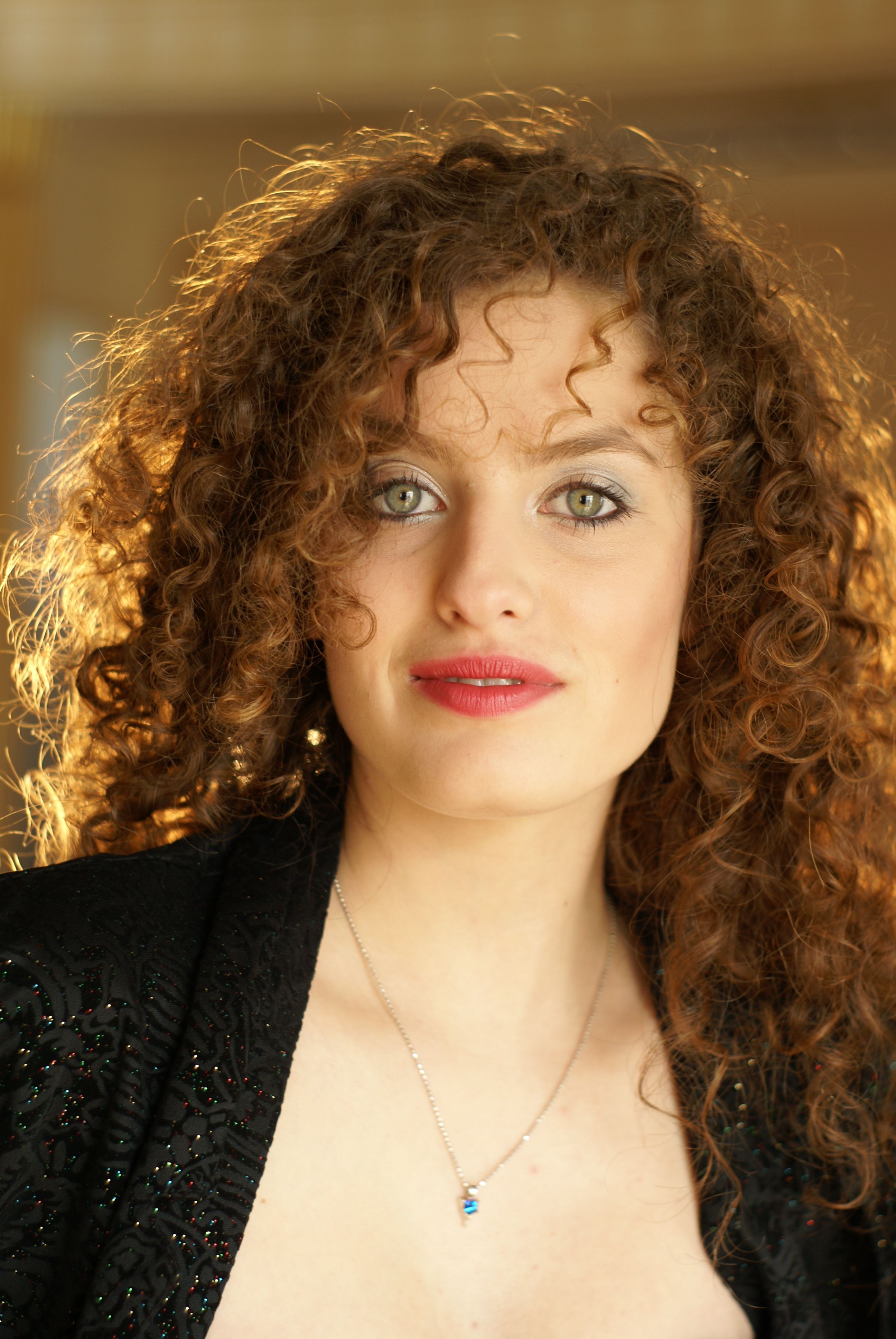A woman with curly hair and a black jacket · Free Stock Photo