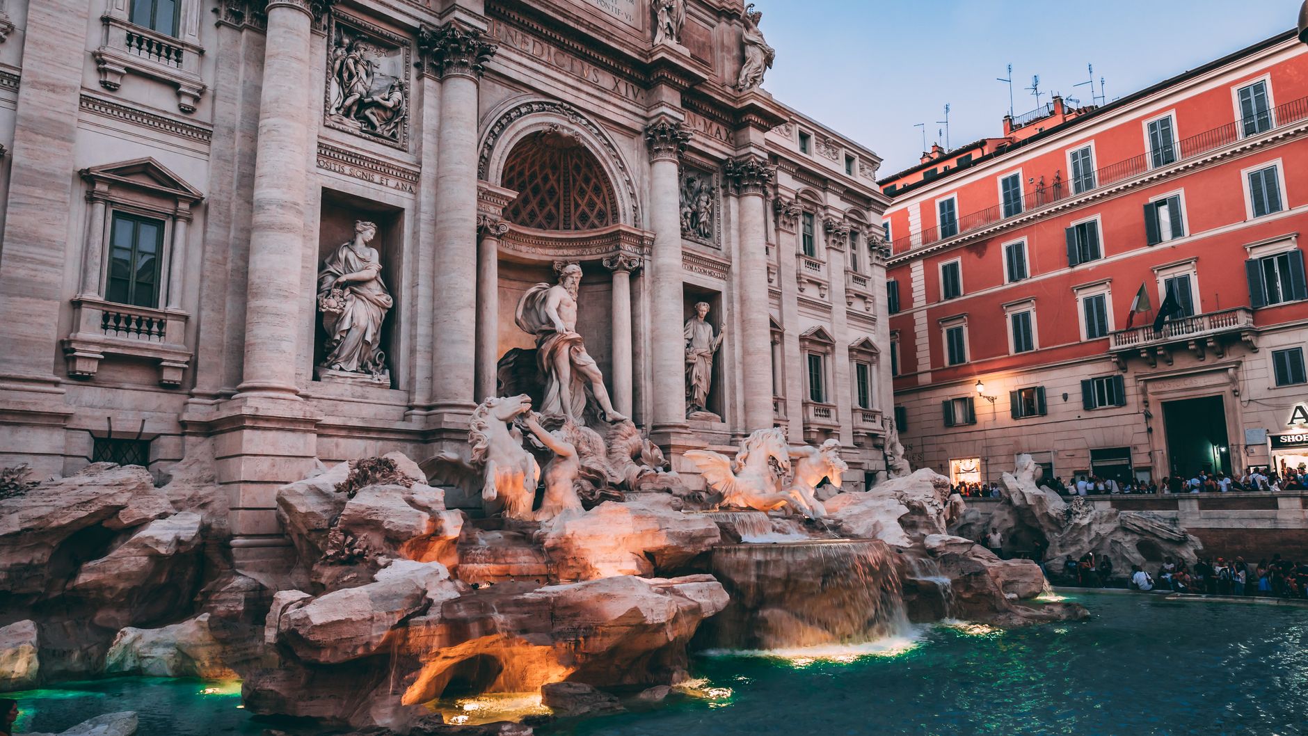 The iconic Trevi Fountain in Rome, a masterpiece of Baroque architecture, captured at dusk.