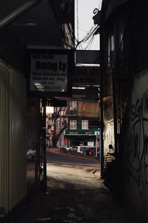 Free A dark urban alleyway featuring city graffiti and signs, capturing a moody ambiance. Stock Photo
