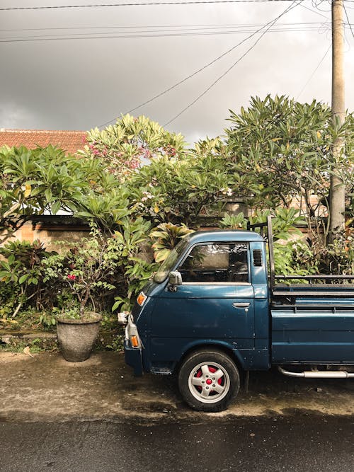 A blue truck parked on the side of the road