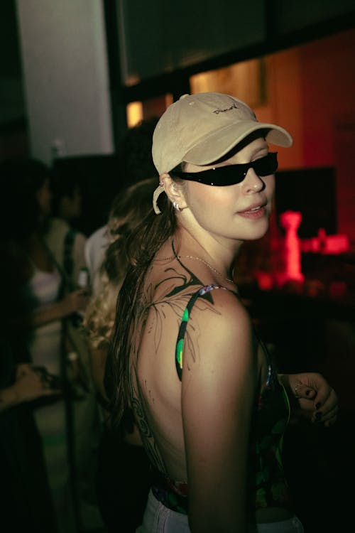 Free A woman in sunglasses and a hat at a party Stock Photo