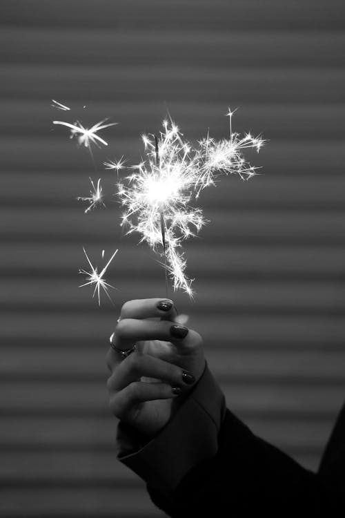 Black and White Photo of a Woman Holding a Sparkler