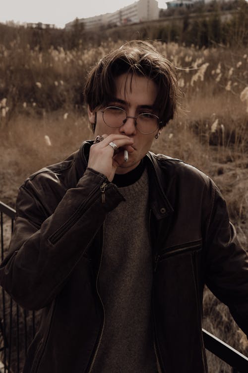 A man smoking a cigarette in a field