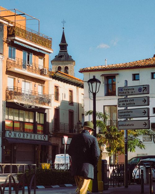 Free A man walks on a sunny day through a charming street in a Spanish town with historic architecture. Stock Photo