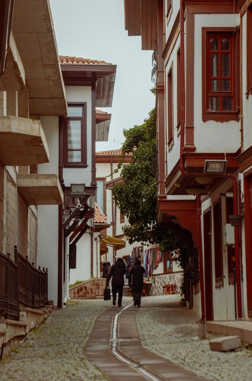 Free A picturesque street with historical buildings and people walking, creating a quaint urban scene. Stock Photo