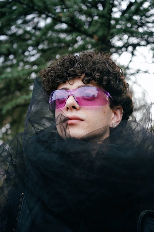 A man with purple sunglasses and a black veil