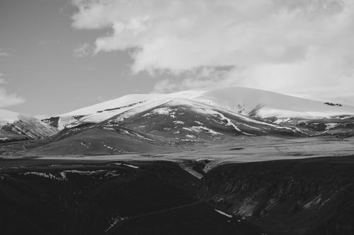 Free Dramatic snow-covered mountain range against a cloudy sky in monochrome. Stock Photo