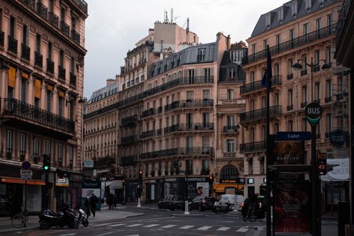 Free Charming Paris street intersection with classic Haussmann architecture and bustling city life. Stock Photo