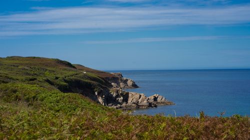 Free Breathtaking view of rocky cliffs along a serene ocean coastline under a clear blue sky. Stock Photo