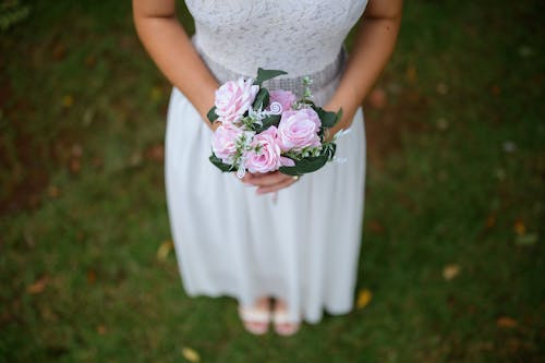 A woman in a white dress holding a bouquet