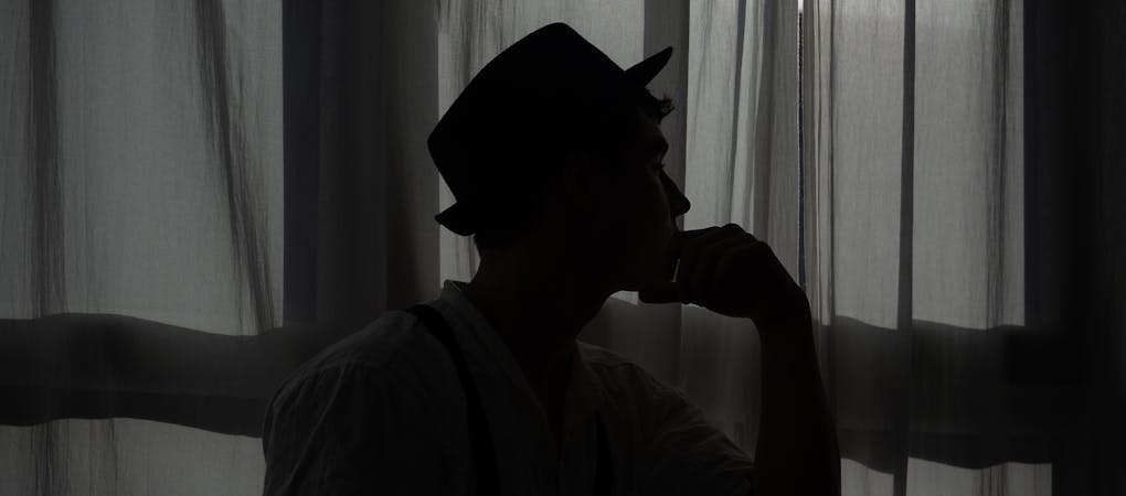 A screenshot of the Prelovedd recommerce builder interface. and a large, dark, silhouette photograph of a man wearing a hat.