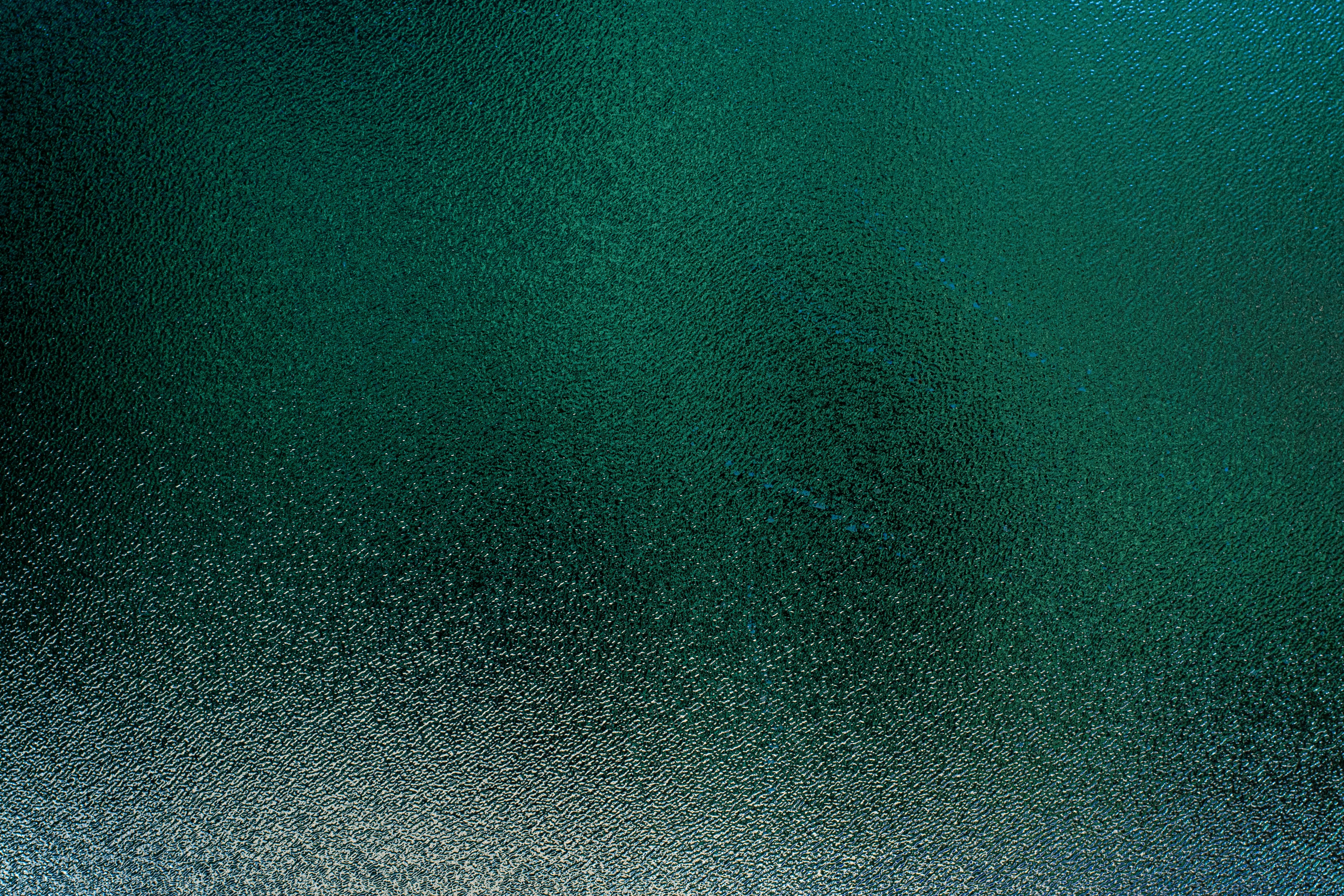 一张纹理抽象的图像，展现了带有绿色和蓝色调的水面涟漪