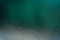 一张纹理抽象的图像，展现了带有绿色和蓝色调的水面涟漪