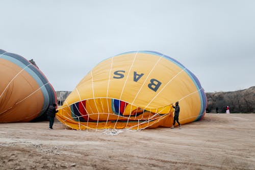 Two people are standing next to a hot air balloon