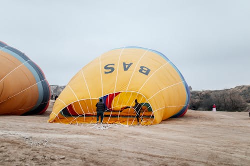 People standing around a hot air balloon in the desert