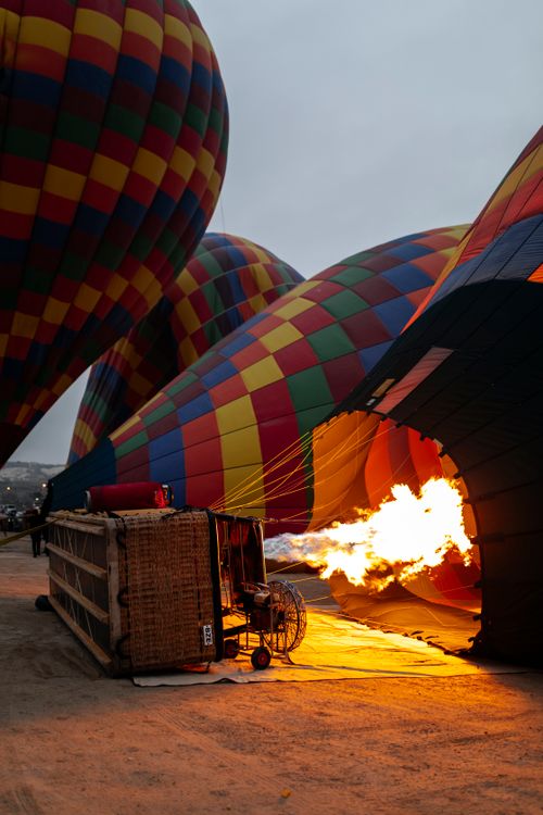 Free Colorful hot air balloons inflating with flames illuminating the scene at dawn. Stock Photo