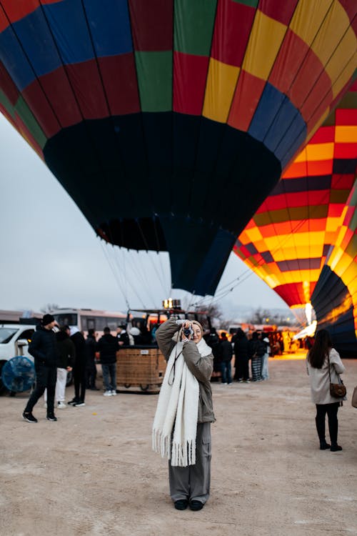 A woman taking a picture of a hot air balloon