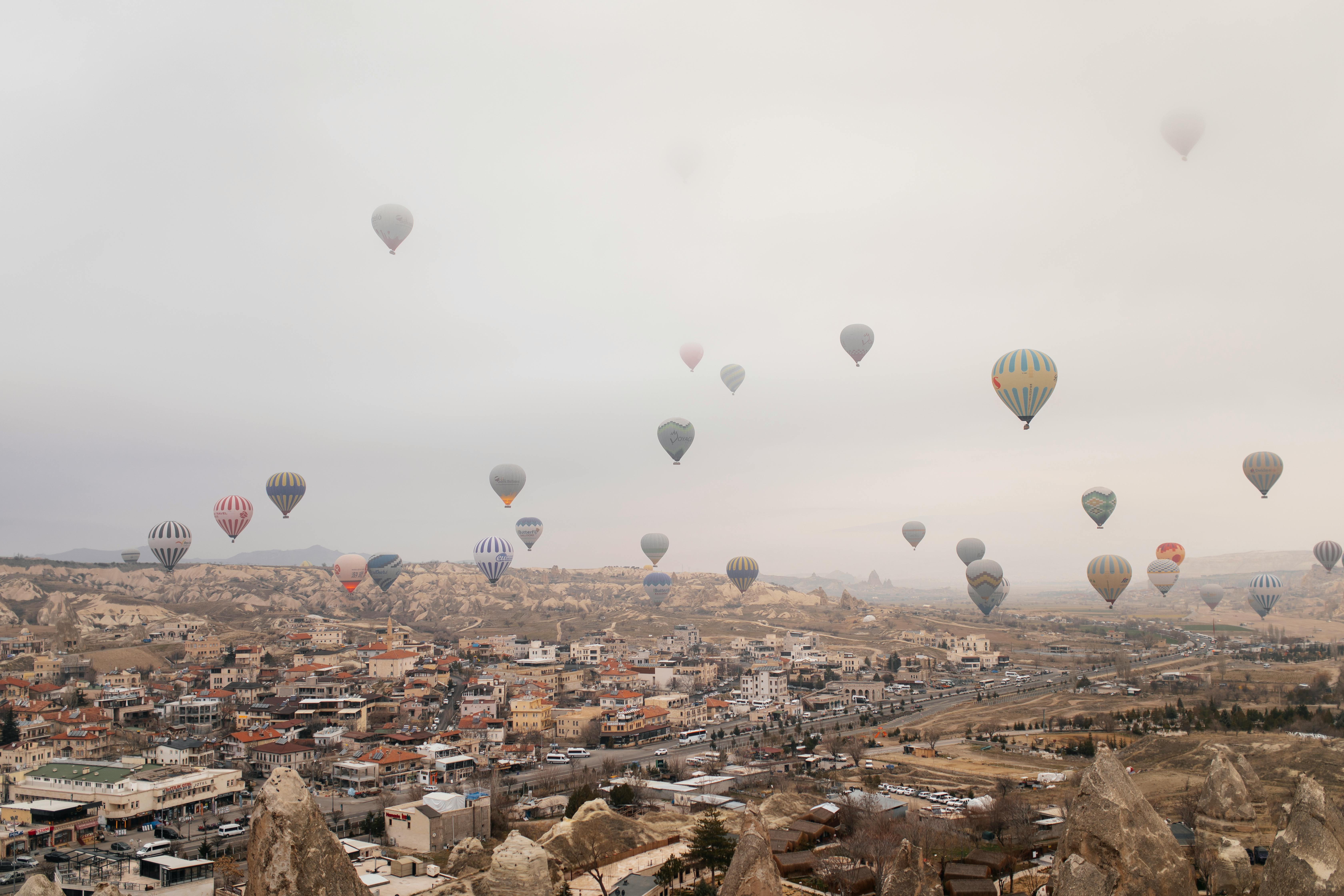 Hot air balloons soar above Cappadocia's stunning rock formations and scenic townscape.
