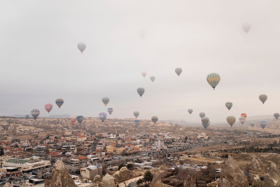 Hot air balloons soar above Cappadocia's stunning rock formations and scenic townscape.
